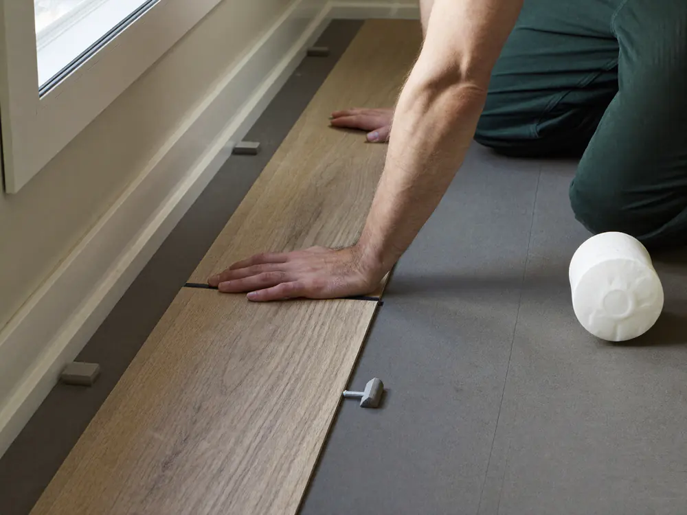Klik-PVC plank wordt in de klikverbinding gekanteld op een ondervloer