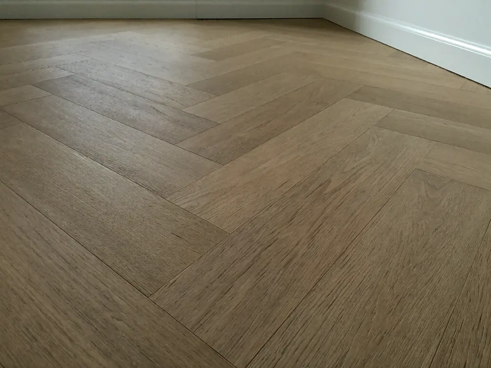 Visgraat PVC vloer in warm eiken van dichtbij